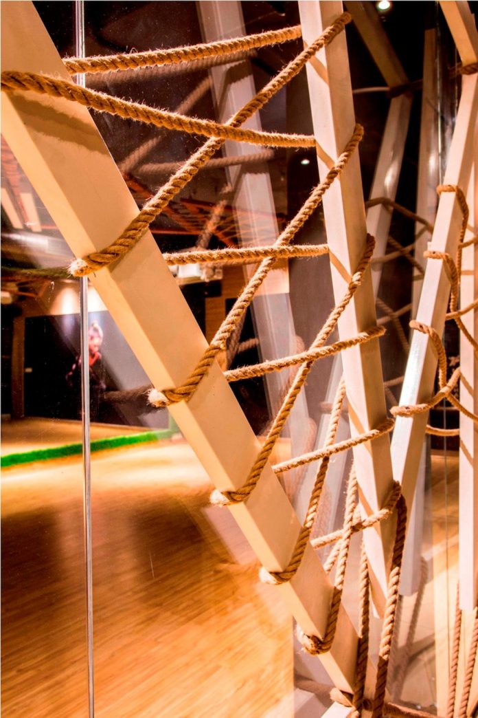 Moksha fitness and spa with overlapping and free standing triangular metal frames, crisscrossed with ropes, designed by Studio Ardete-14