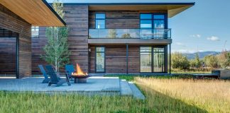 Contemporary mountain house set on a flat, open, grassy site in Jackson Hole, Wyoming