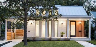 North Hyde Park Residence has a long porch and modern vertical windows which penetrate the painted brick portion of the facade