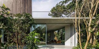 Concrete house placed close to the seashore and surrounded by a dense and rich rainforest vegetation