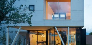 Concrete house uses old walls to create private patio allowing to add full glass walls to the residence