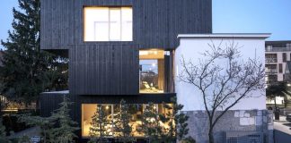 Extension and renovation that adds 3 new rectangular volumes covered in dark wood by Ofis Arhitekti
