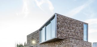 Narrow, long and tall house covered in vivacious bricks that brings texture and character to the whole